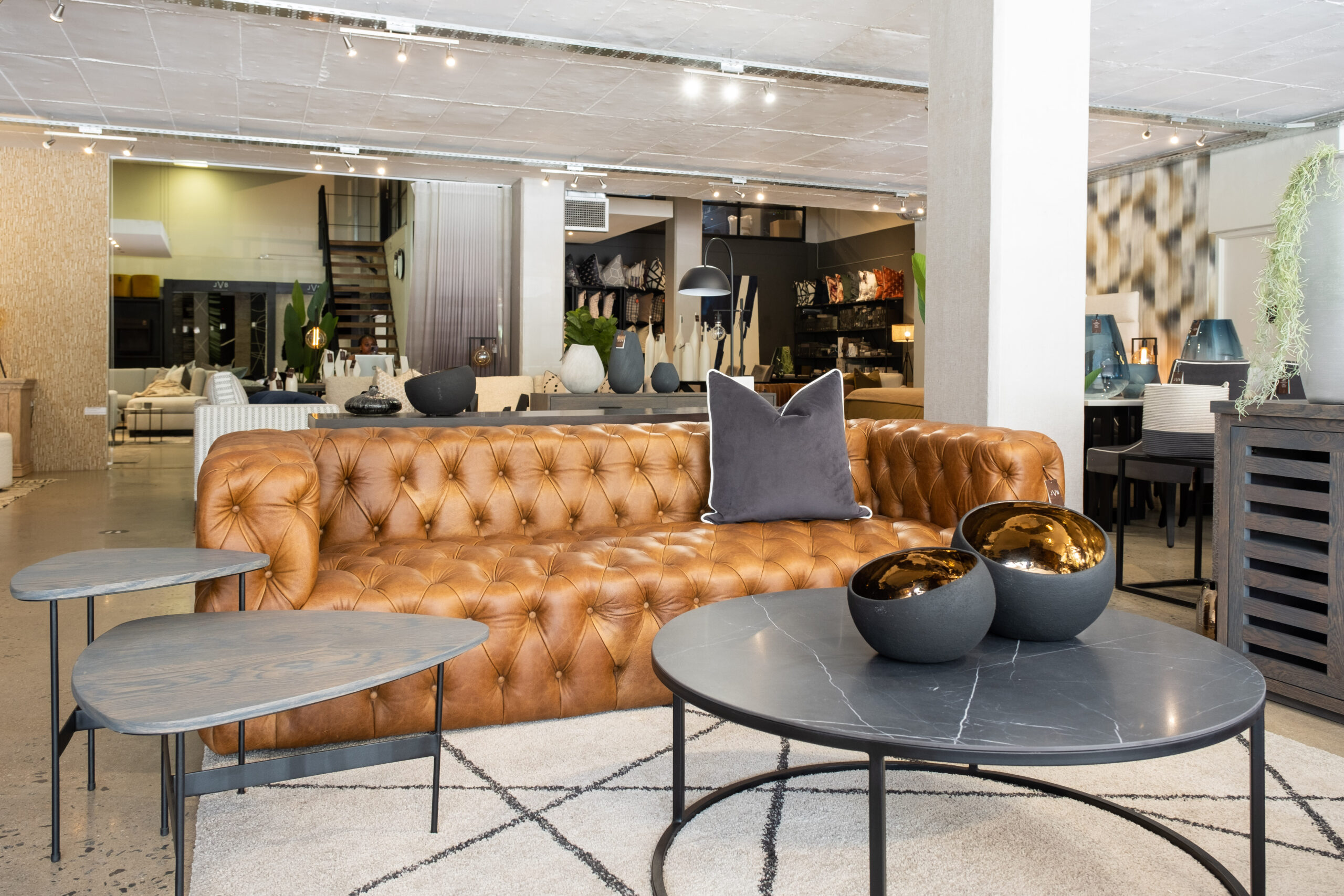 JVB showroom with a leather couch and made-to-order round coffee table with a marble effect
