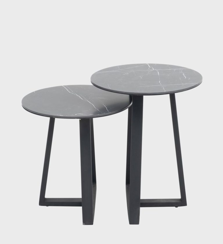 The Judd Nesting Side Tables are a sleek pairing of modern geometry and refined materiality. Each table features a circular top in dark marble with delicate white veining, supported by angular black metal legs that form a stable triangular base.