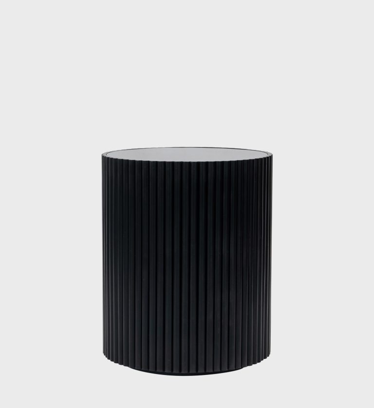 The Fluted Side Table Ebony is a sleek embodiment of modern elegance. Its cylindrical form features vertical ribbing that adds texture and rhythm, while the smooth top provides a refined contrast.