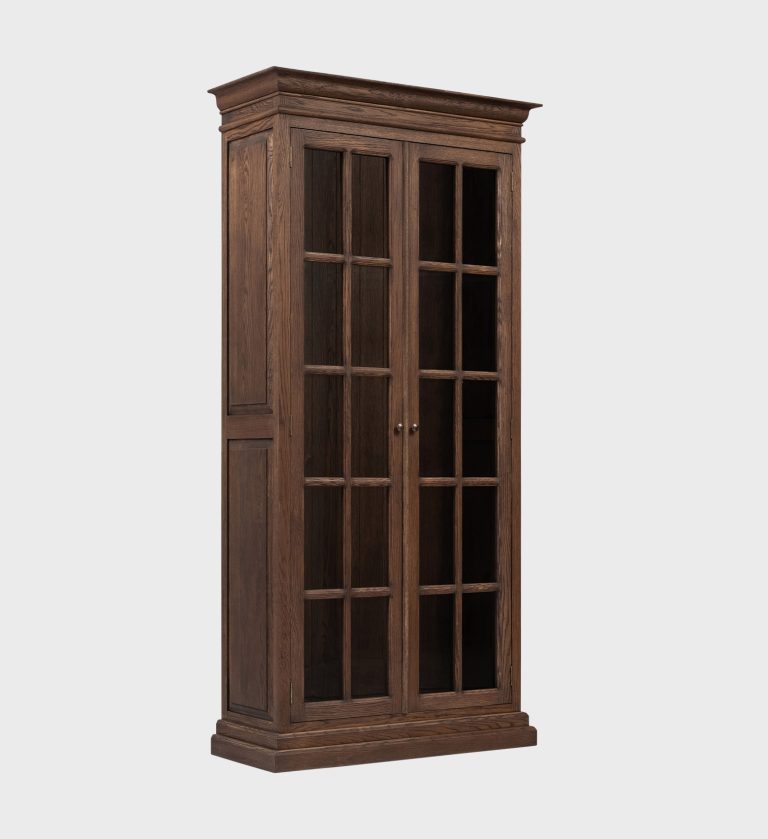The Chedworth Book Cabinet Narrow showcases timeless craftsmanship with its rich wood finish and classic paneled glass doors.
