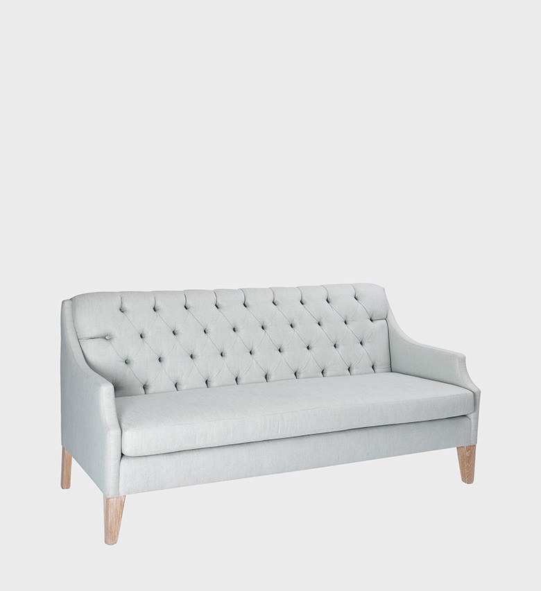 The Phoebe Sofa is a graceful blend of classic charm and modern refinement. Upholstered in a soft, pale gray fabric,