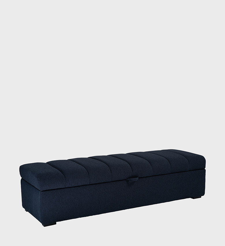 The Fluted Ottoman combines refined craftsmanship with functional elegance. Upholstered in deep navy fabric, its softly fluted top adds texture and visual rhythm, while a discreet front handle reveals hidden storage within.