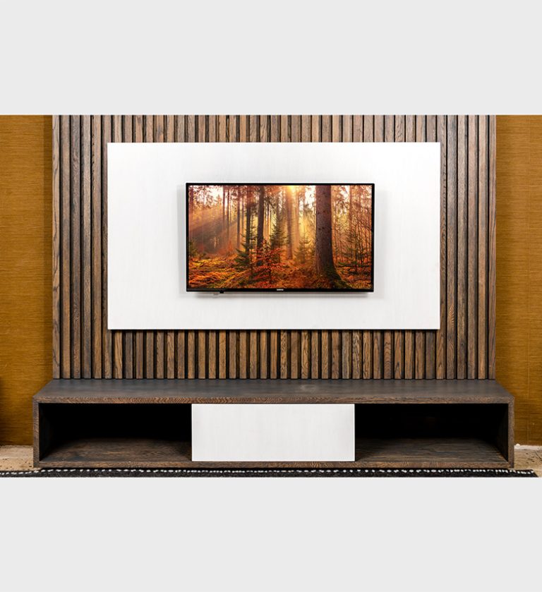 The Prime AV Unit Storm / French White is a sophisticated blend of modern craftsmanship and natural warmth. Its design features a textured backdrop of vertical wooden slats in a rich storm finish, contrasted by a crisp French White panel that frames the mounted television