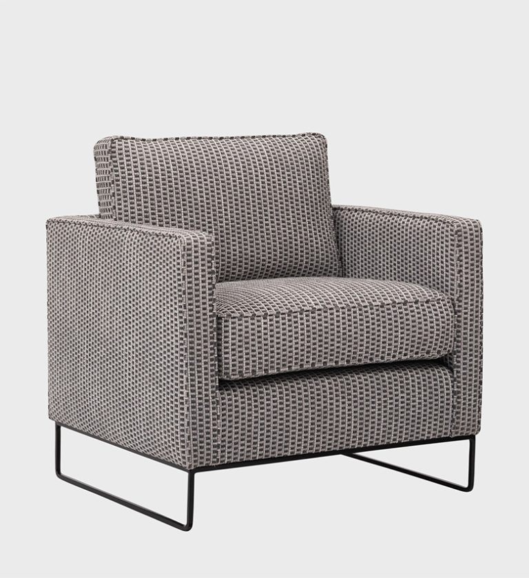 The Manhattan Armchair is a bold fusion of classic pattern and modern form. Upholstered in a striking black‑and‑white houndstooth fabric