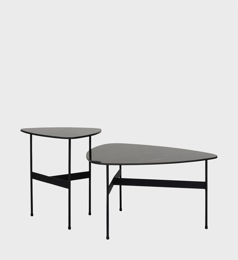 The Plectra Side Table Set showcases a harmonious blend of organic form and minimalist structure. Each table features a smooth, asymmetrical top with softly rounded edges, supported by slender black metal legs joined by geometric crossbars for stability and visual balance. The contrasting heights allow for dynamic arrangements, making this set ideal for modern interiors that value fluid design and understated sophistication.