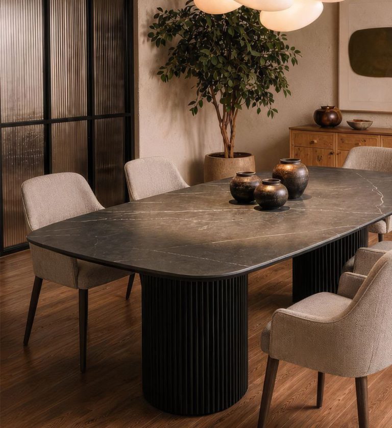The Dolce Vita Oval Dining Table is a refined statement of modern luxury. Its smooth, marble‑effect top with soft veining rests on two cylindrical, fluted bases finished in deep black