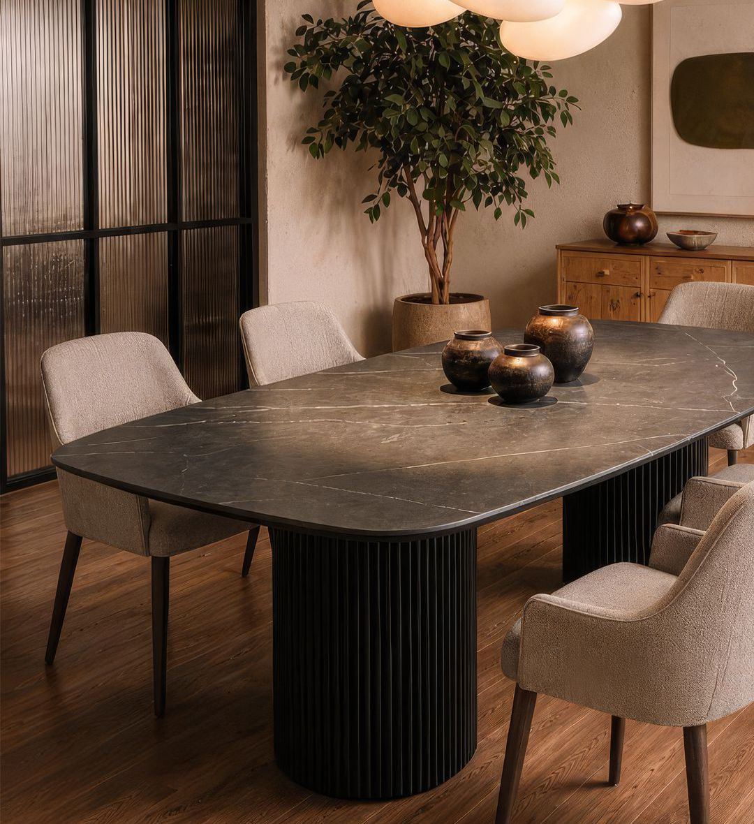 The Dolce Vita Oval Dining Table is a refined statement of modern luxury. Its smooth, marble‑effect top with soft veining rests on two cylindrical, fluted bases finished in deep black