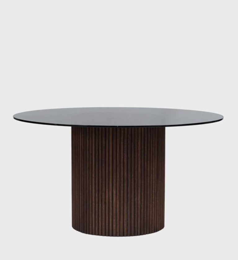 The Luvuvhu Round Dining Table Walnut is a sophisticated blend of organic warmth and modern geometry. Its circular top, finished in a smooth dark surface, rests on a cylindrical base adorned with vertical walnut fluting that adds rhythm and texture.