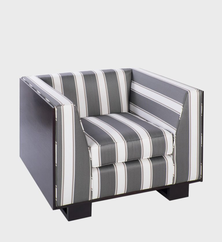 The Mellor Armchair is a striking blend of modern geometry and tailored sophistication. Its bold striped upholstery in shades of grey and white creates a crisp